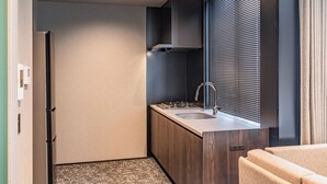 A compact kitchen with a built-in stove, sink, and ventilation hood.
