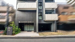 A modern multi-story building with a sign reading "APARTMENT HOTEL 11".