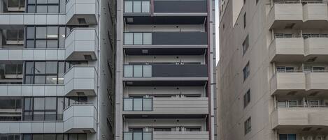 Un edificio de varios pisos con un diseño arquitectónico moderno, que cuenta con balcones y ventanas amplias.