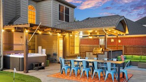 A covered patio with a dining table and chairs, a hot tub, and a barbecue area. - The Painted Paddle: Pool, HotTub, Pickleball Court (Lake Dallas)