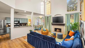 A spacious living area with a large sofa, a fireplace, and a television. - The Painted Paddle: Pool, HotTub, Pickleball Court (Lake Dallas)