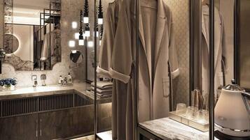 A modern bathroom with a large mirror, a vanity with a marble countertop, and a built-in shower area.