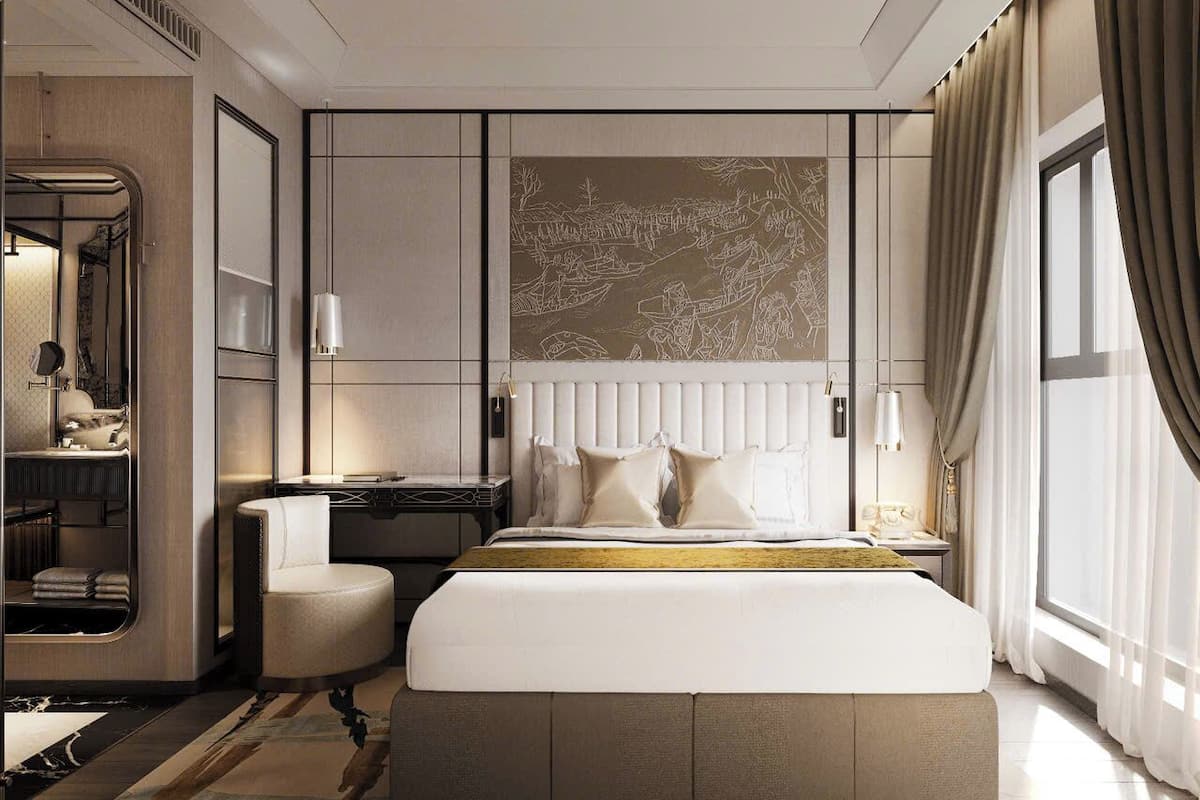 A modern hotel room with a large bed, a desk, and a seating area.