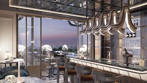 Uma área de bar moderna com pé direito alto, grandes janelas e vista para a cidade.