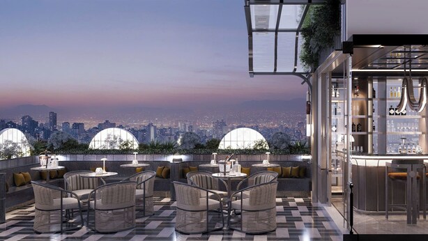 Um bar no terraço com mesas ao ar livre e vista para a cidade.