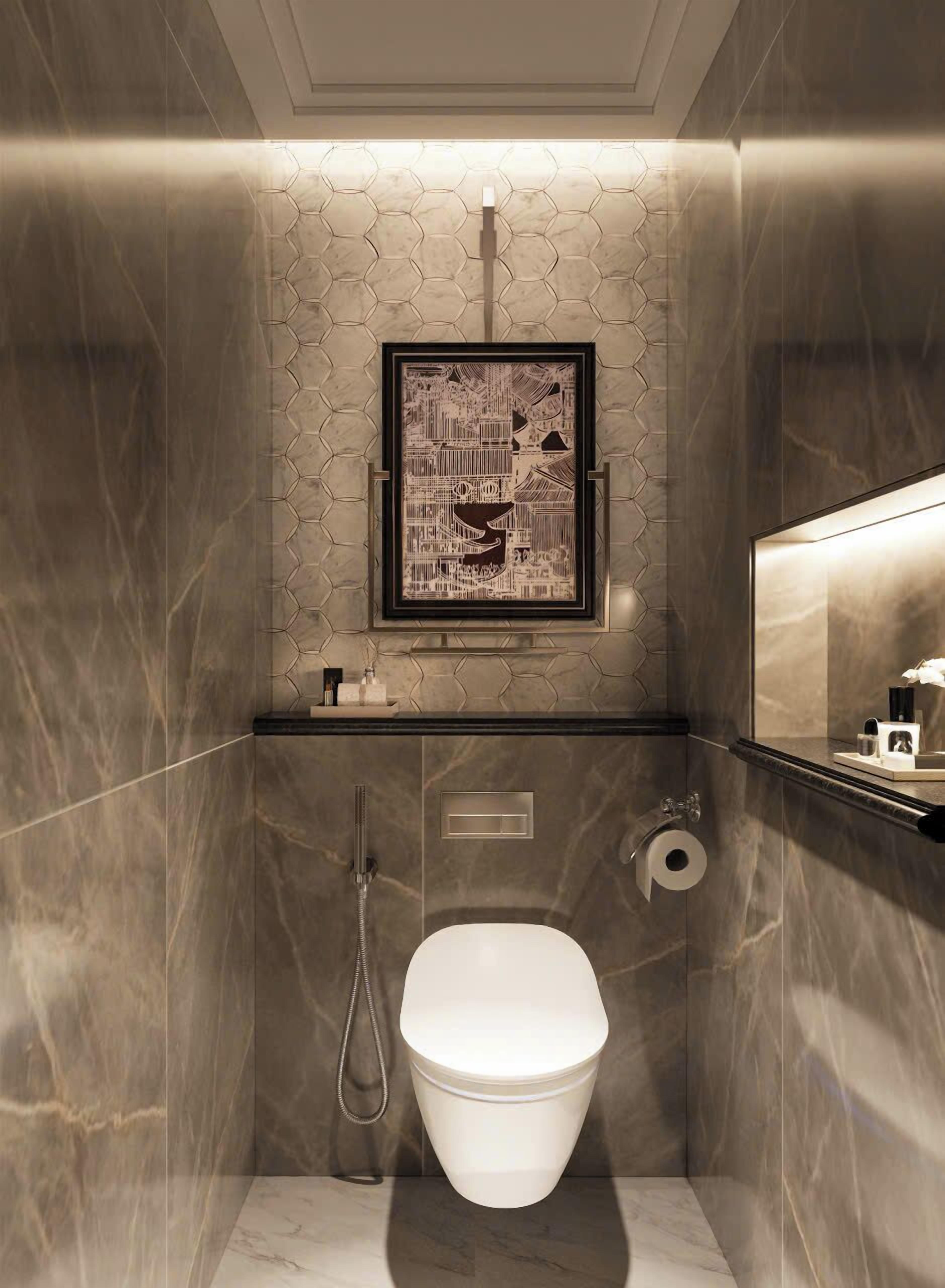 A modern bathroom with a hexagonal patterned wall, a framed artwork, a toilet, and a shower.