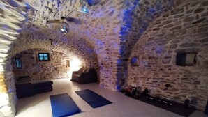 An arched stone room with a massage table, two massage mats, and a small window. - Mes Maisons Charming 3-bedroom Gite with AC, fitness room in delightful Cevennes (Gagnières)