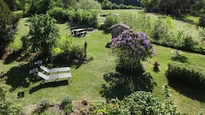 A grassy outdoor area with a picnic table, a small shed, and a tree with purple flowers. - Holiday Apartment 60sqm, 2 Bedrooms, Max. 4 Persons, 4 Stars - DTV Classified (Hayingen)