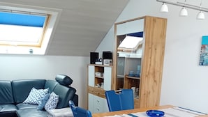 A modern living space with a dining area, a sofa, and a wooden cabinet. - Holiday Apartment 60sqm, 2 Bedrooms, Max. 4 Persons, 4 Stars - DTV Classified (Hayingen)