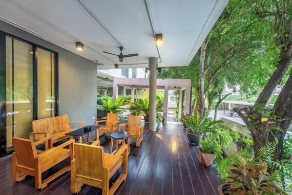 An outdoor seating area with wooden furniture and potted plants.