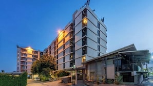 Ett hotell med flera våningar och modern design, med balkonger och en överbyggd entré.