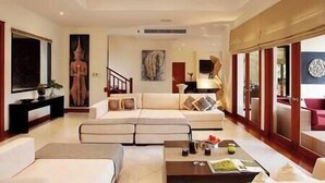 A spacious living room with a large sofa, a coffee table, and artwork on the walls. - Laguna Waters - Lake View Villa, 5 Bedrooms (Bang Tao)