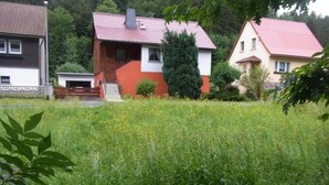 Um bairro residencial com casas, um campo gramado e árvores.