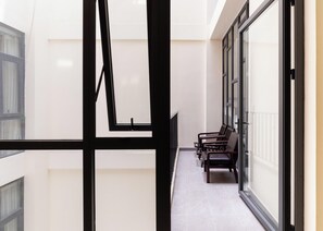 A corridor with a bench, a door, and a window. - Studio Room in Modern building with AC in vibrant HCM; 1.3km from TSN airport (Hồ Chí Minh)