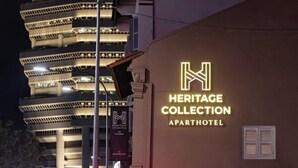 La façade de l’hôtel-résidence Heritage Collection, avec son enseigne lumineuse bien visible.