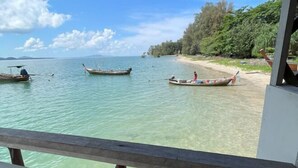 Ein Strand mit klarem Wasser, Booten und einer Holzkonstruktion.