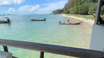 Una vista despejada de una playa con barcos y una cubierta de madera.