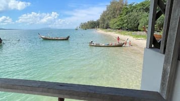 Une plage avec une eau cristalline, des bateaux et une structure en bois.