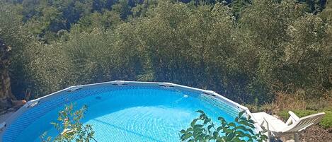 Una piscina amb vistes a un paisatge urbà i a les colines al fons.