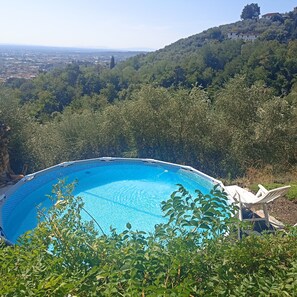 A swimming pool with a view of a cityscape and hills in the background.