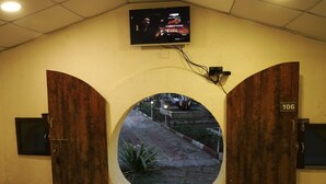 L’entrée d’un hôtel, avec un téléviseur fixé au-dessus d’une arche circulaire.