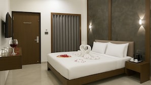 Une chambre d’hôtel avec un lit, une table de chevet avec une machine à café, une télévision et un rideau.