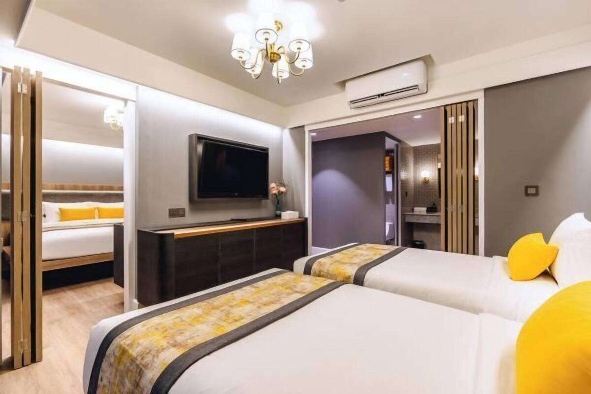 Une chambre d’hôtel avec deux lits, une télévision et un minibar.