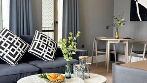 Una sala moderna con sofá, mesa de centro y comedor.