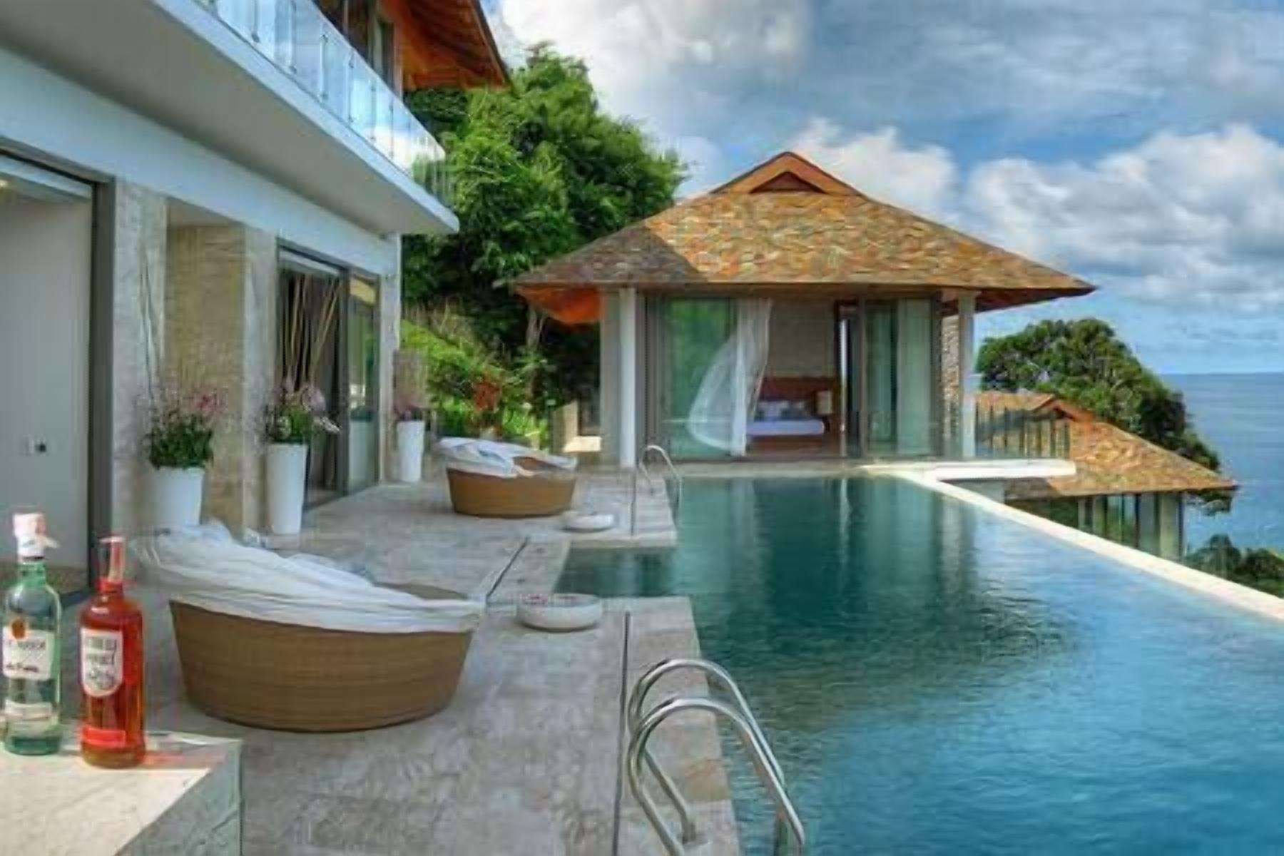 A poolside area with a lounge chair, a small table, and a bottle of water.