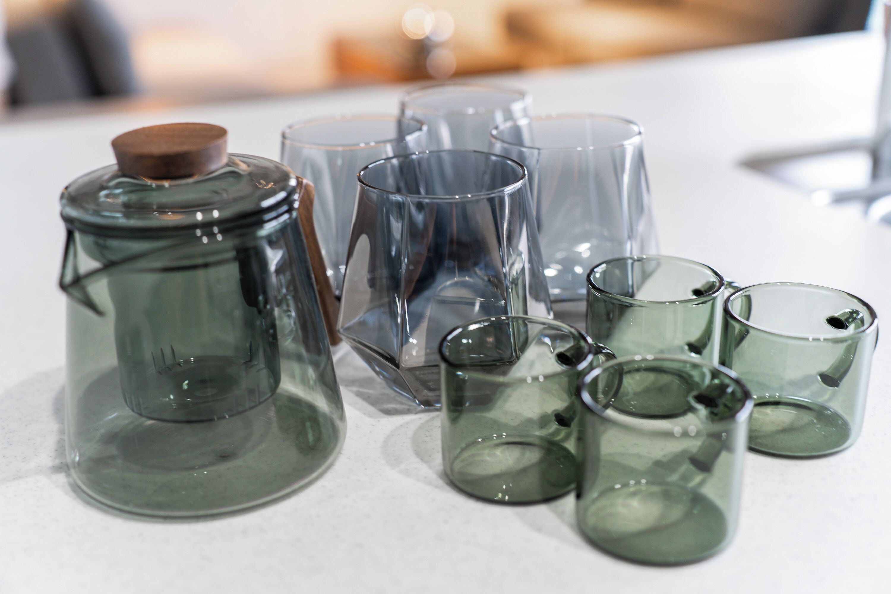 A collection of clear glass containers of various shapes and sizes on a white surface.
