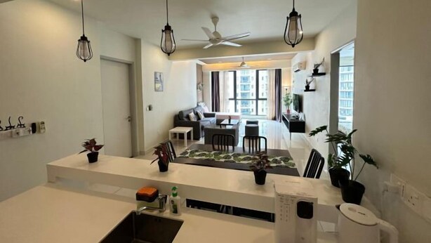 A modern kitchen with a central island, pendant lighting, and a view into the living area. - JazzA Suite by Homey Planet (Tanjung Tokong)