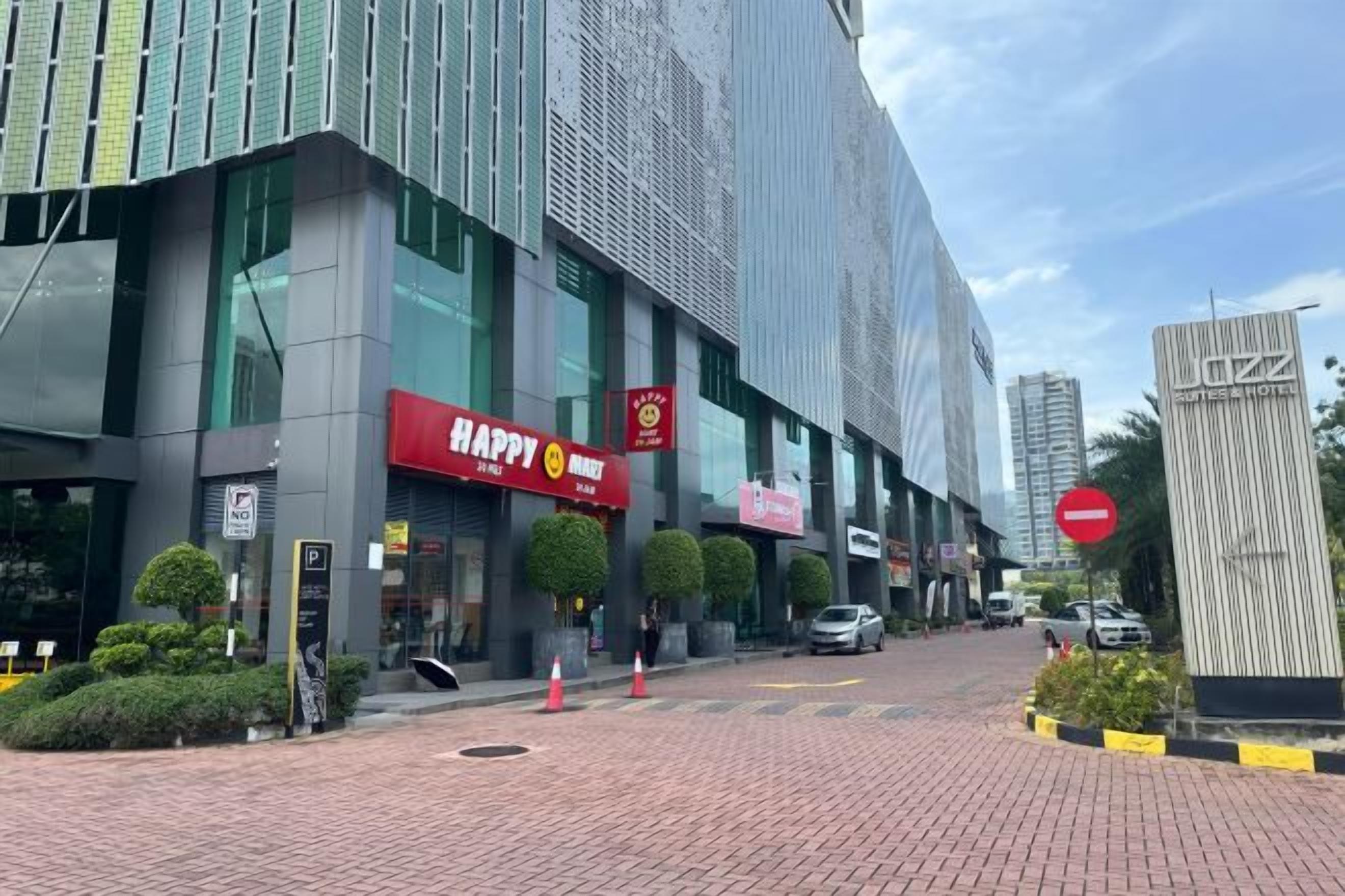 Een modern gebouw met een 'HAPPY' bord, een 'SUNTHEA HOTEL' bord en een 'TOEGANG VERBODEN' bord.