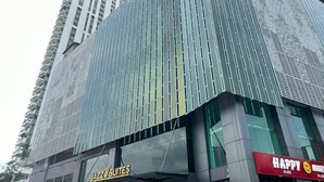 A modern building with a glass facade and a sign for "JAZZ SUITES" on the lower level. - JazzA Suite by Homey Planet (Tanjung Tokong)
