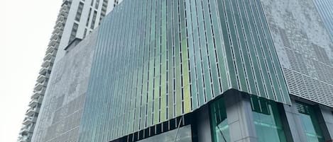 A modern building with a glass facade and a sign for "JAZZ SUITES" on the lower level.