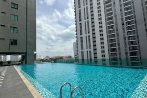 A swimming pool surrounded by high-rise buildings. - JazzA Suite by Homey Planet (Tanjung Tokong)