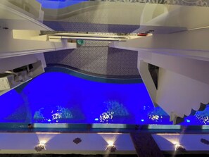 Un interior moderno con zona de piscina, que incluye un área de estar y una piscina iluminada.