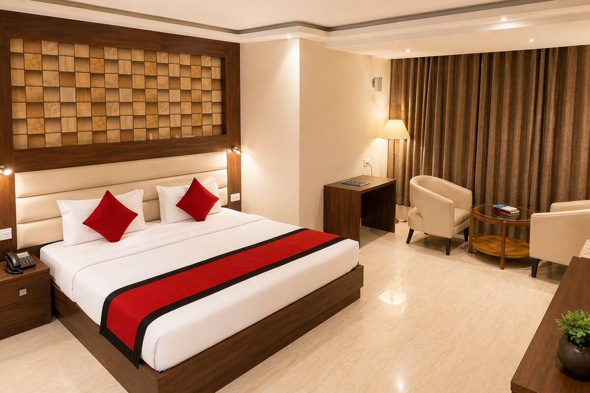 Una habitación de hotel con una cama grande, mesitas de noche, un escritorio, una silla y una lámpara.