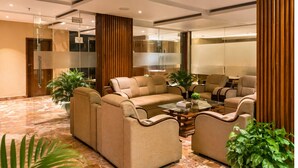 A modern lobby with a sofa set, a coffee table, and potted plants. - 8fold by LaRiSa, Basti (Basti)