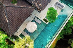Luchtbeeld van een huis met zwembad, overdekt terras en een tuin.