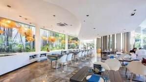 Un restaurante moderno con techo curvo, ventanas amplias y suelo de mármol pulido.