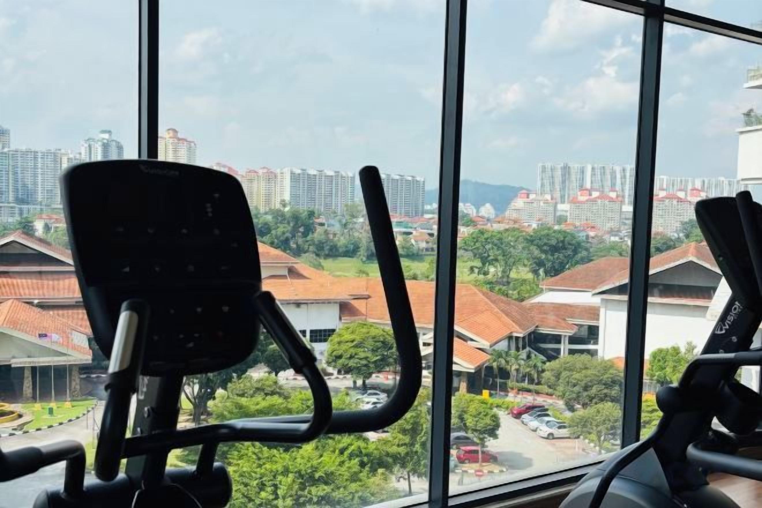 An office chair in a room with large windows overlooking a cityscape.