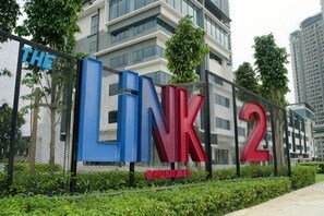 A fence with large letters spelling 'LINK 2' and a building in the background.