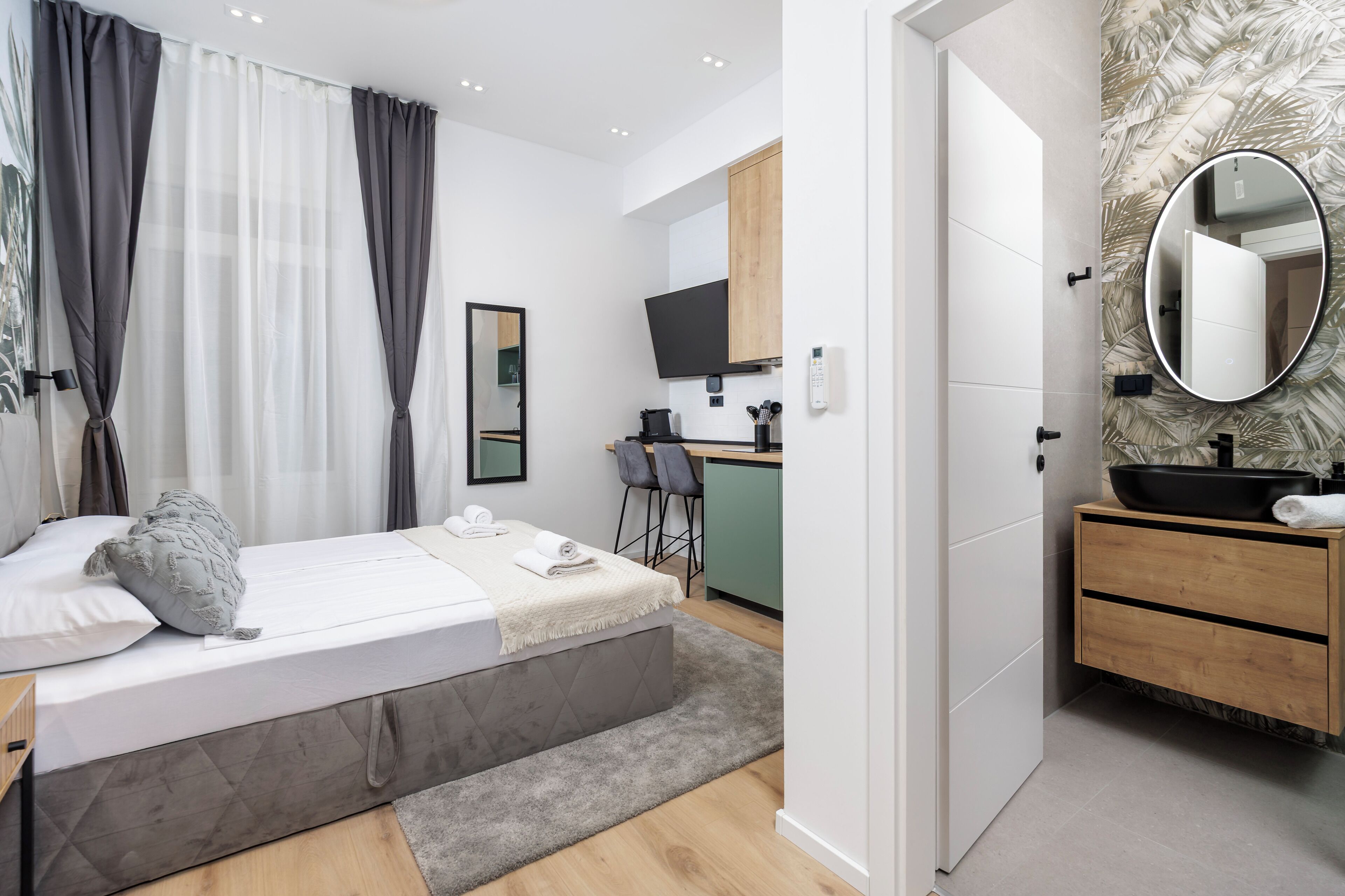 Une chambre moderne comprenant un lit, une table de chevet et un petit espace bureau avec une chaise.
