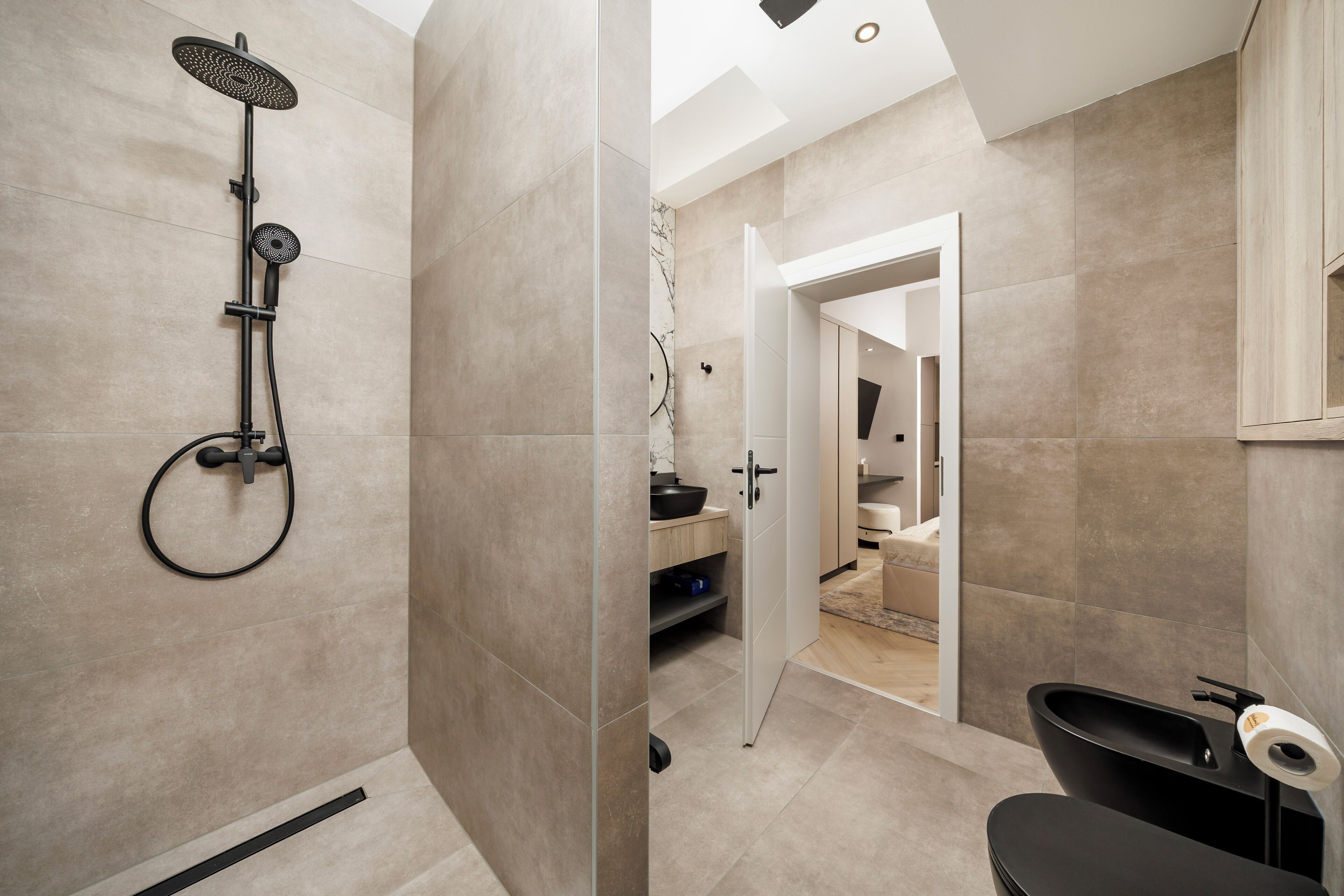 A modern bathroom with a shower, toilet, and sink.