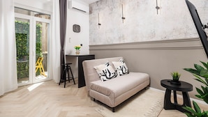 A modern living room with a sofa, a small table, and a large window with curtains. - Marvie Apartments (Rijeka)