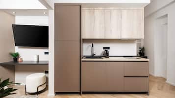 A modern kitchen with a built-in oven, a sink, and a wooden cabinet above the countertop.