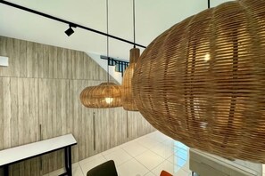A modern interior with a wooden wall, a white table, and a large woven light fixture. - Villa 19 Private Pool Langkawi (Langkawi)