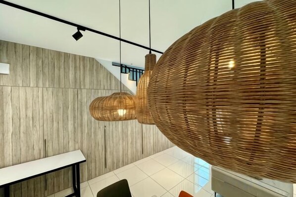 A modern interior with a wooden wall, a white table, and a large woven light fixture. - Villa 19 Private Pool Langkawi (Langkawi)