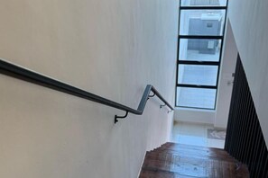 A staircase with a metal handrail and a wooden floor, leading to a room with a large window. - Villa 19 Private Pool Langkawi (Langkawi)