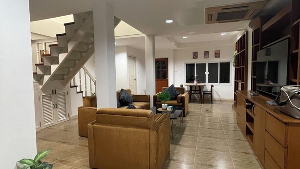 A spacious living area with a staircase, a dining area, and a kitchen. - Lovely 3-bedroom house with AC in Minburi (Krung Thep Maha Nakhon)